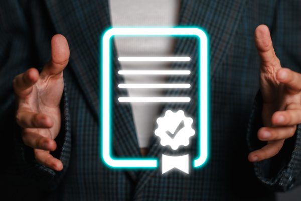 Mains tenant un hologramme d'icône de document certifié avec badge, devant une veste à carreaux.