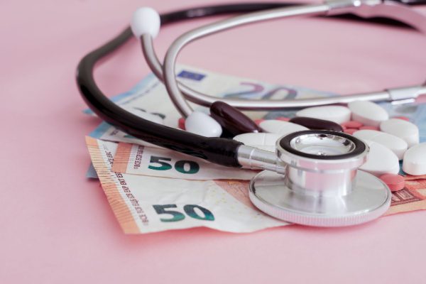 Stéthoscope et médicaments posés sur des billets en euros, symbolisant les coûts de la santé à Mayotte.